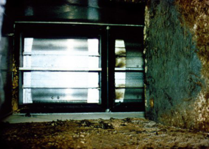 Interior view of a dirty HVAC duct with grilles, showing mold and debris, addressed by Air-Zone Inc. in Suffolk, VA.