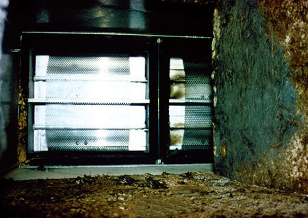 Interior view of a dirty HVAC duct with grilles, showing mold and debris, addressed by Air-Zone Inc. in Suffolk, VA.
