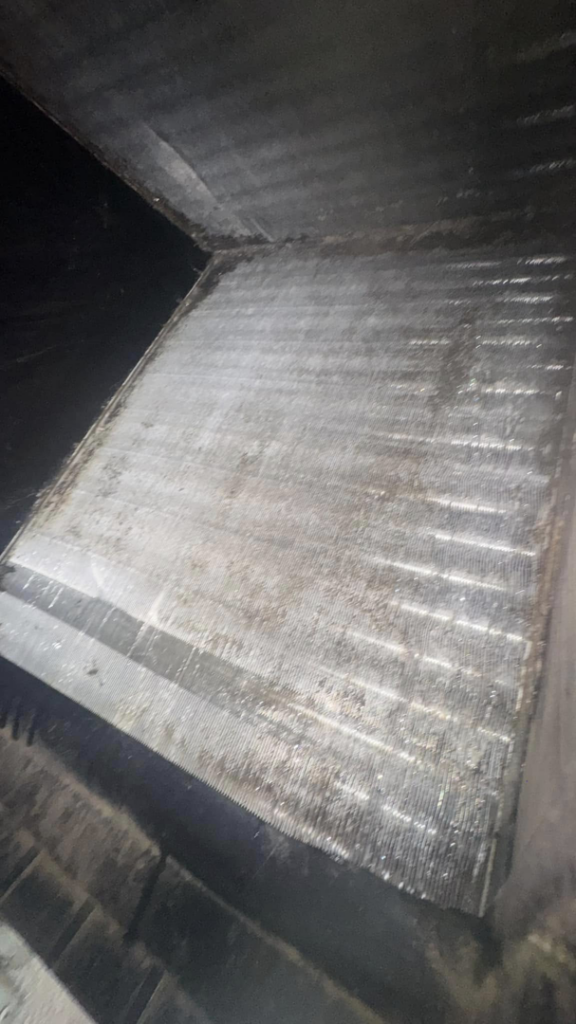 A dirty HVAC evaporator coil covered in grime, indicating a need for cleaning and maintenance from Charlie Foxtrot HVAC in Gilbert, AZ.