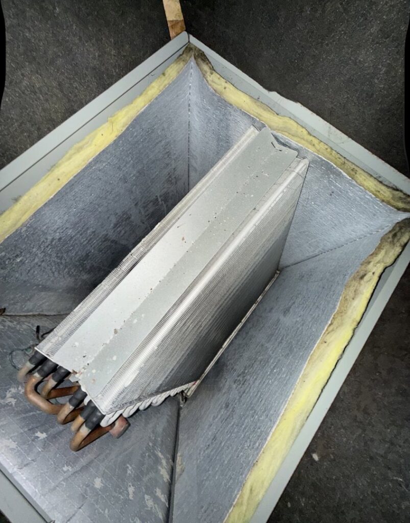 A close-up view of a dirty HVAC evaporator coil, ready for professional cleaning by Duct Doctor of Baton Rouge, LA.