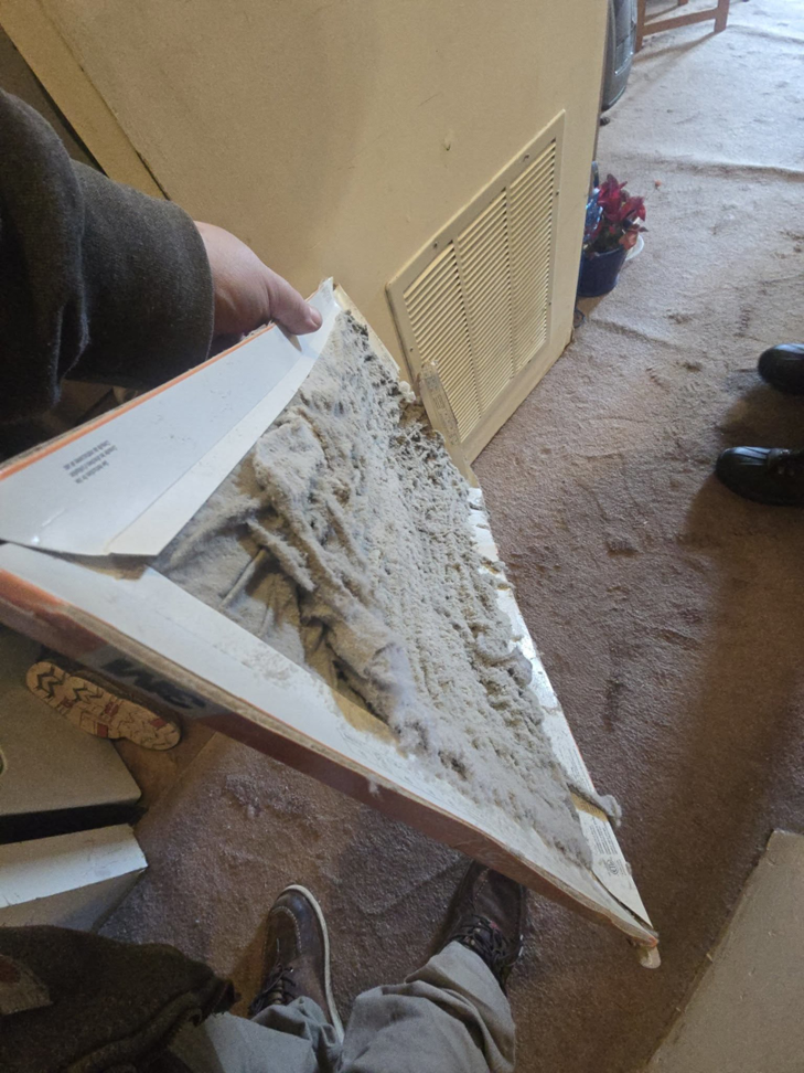 A technician holding a very dirty HVAC filter, indicating the need for replacement by Comfort-Tech llc in Alexandria, VA.