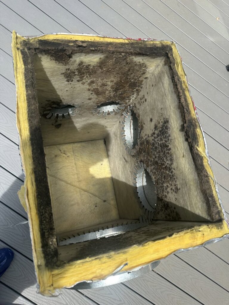 A dirty, insulated HVAC duct section, possibly removed for cleaning or replacement by Arctic Desert Cooling & Heating in Concord, NC