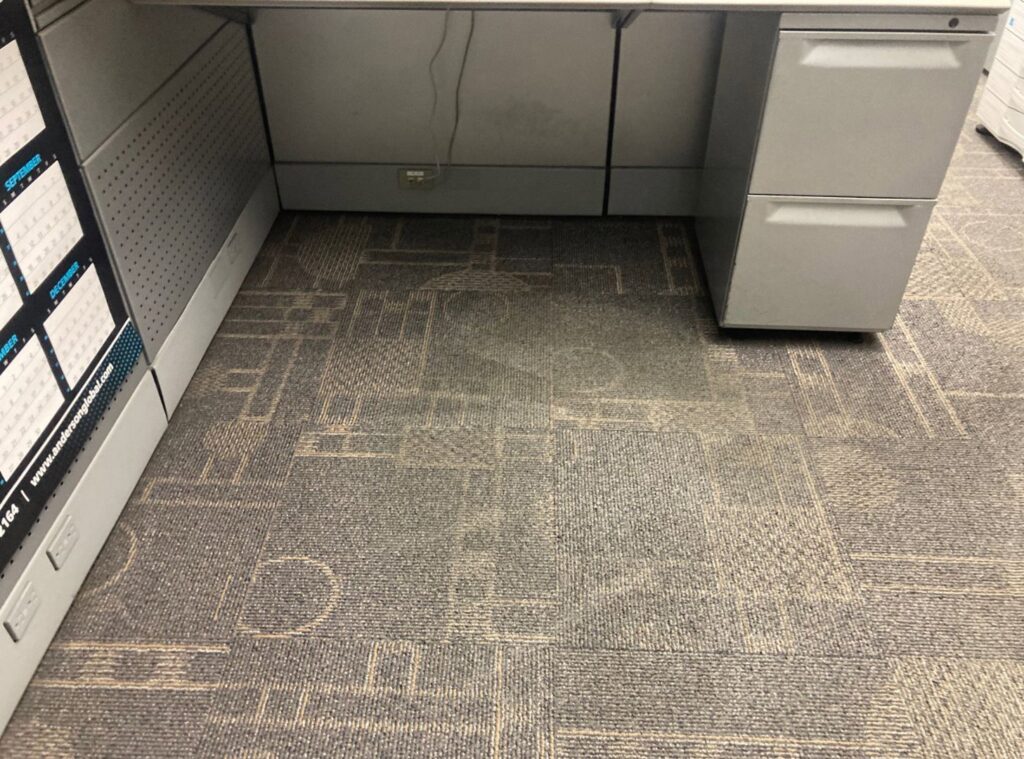 An office carpet under a desk, showing wear and dirt before cleaning by Olen's Carpet & Upholstery Cleaning LLC in Cleveland, OH.