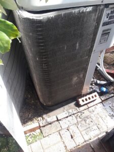A dirty outdoor AC coil before cleaning by Go West A/C & Heating in Fort Worth, TX.