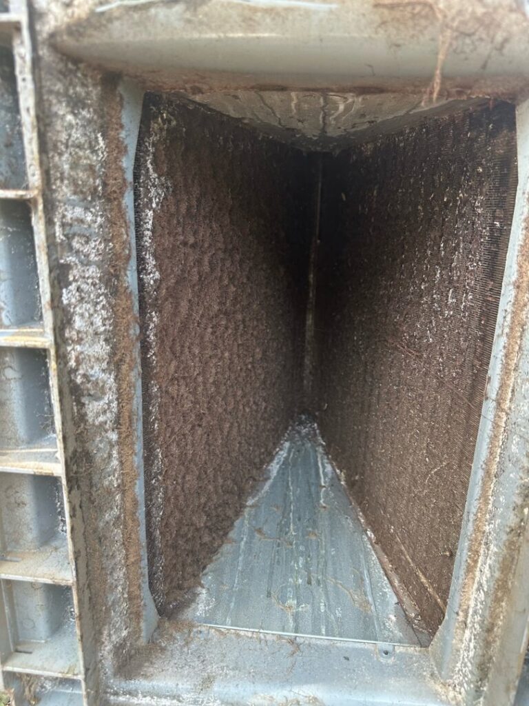 A very dirty outdoor air conditioning coil before cleaning by Zippers Heating and Cooling in Mobile, AL.
