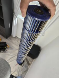 A close-up view of a dirty outdoor AC unit coil needing cleaning from Quantum Cooling & Heating in Mesa, AZ.