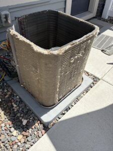 Dirty coils of an outdoor air conditioning unit with the side panel removed, showing a need for cleaning by Holzer Heating And Cooling in Savage, MN
