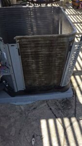An outdoor air conditioning unit with dirty coils exposed, indicating a need for maintenance from Ecology Air Innovations in Sacramento, CA.