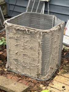 A heavily soiled outdoor air conditioning unit, indicating a need for HVAC service from Apollo Heating and Air in Bellevue, NE.
