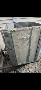 A very dirty outdoor air conditioning unit with coils covered in debris, showing a need for service by Holzer Heating And Cooling in Savage, MN