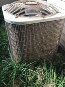 A dirty outdoor air conditioning unit in need of cleaning or service by Family Heating & Air Conditioning in Indianapolis, IN.
