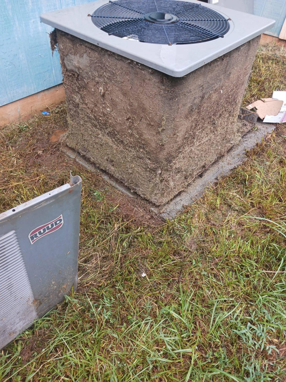 A heavily soiled outdoor AC unit with a removed panel, showing dirty coils, indicating a need for HVAC service by Omaha Heating and Air in Omaha, NE.