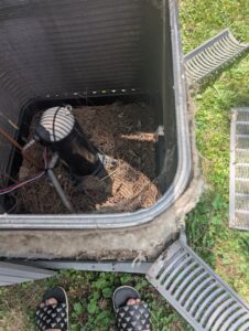 The interior of a dirty outdoor AC unit filled with pine needles, showing a need for service from Falso Service Experts in East Syracuse, NY.