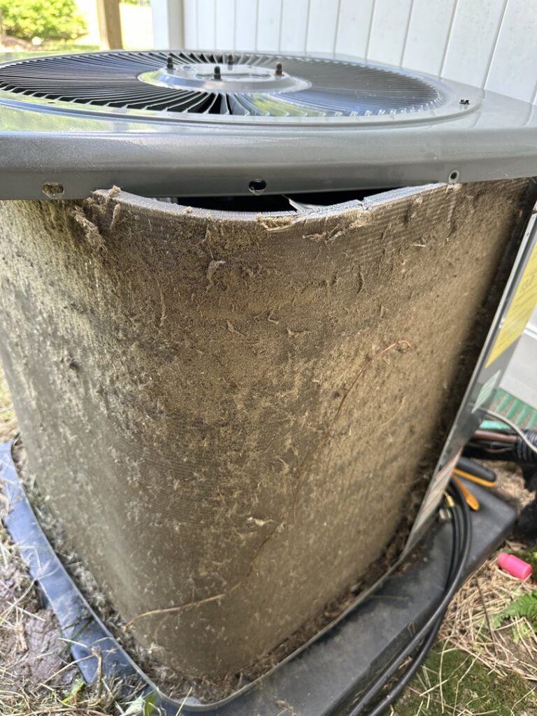 A heavily soiled outdoor AC unit, indicating a need for maintenance from Lighthouse HVAC, LLC in Edgewater, MD.