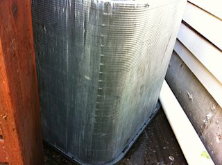 A dirty outdoor air conditioning condenser unit requiring service from Geddes Heating and Cooling in Aurora, CO.