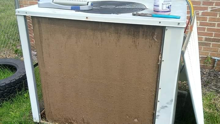 A dirty outdoor HVAC condenser unit with tools on top, ready for cleaning or service by Conway's Heating & Air in Concord, NC.