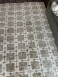 A dirty, patterned area rug with visible stains before cleaning by Safe-Dry Carpet Cleaning of Clarksville, TN