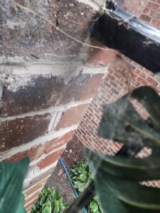 A dirty black porch swing covered in spiderwebs, showing a need for pest control from Moxie Pest Control Charlotte in Charlotte, NC.
