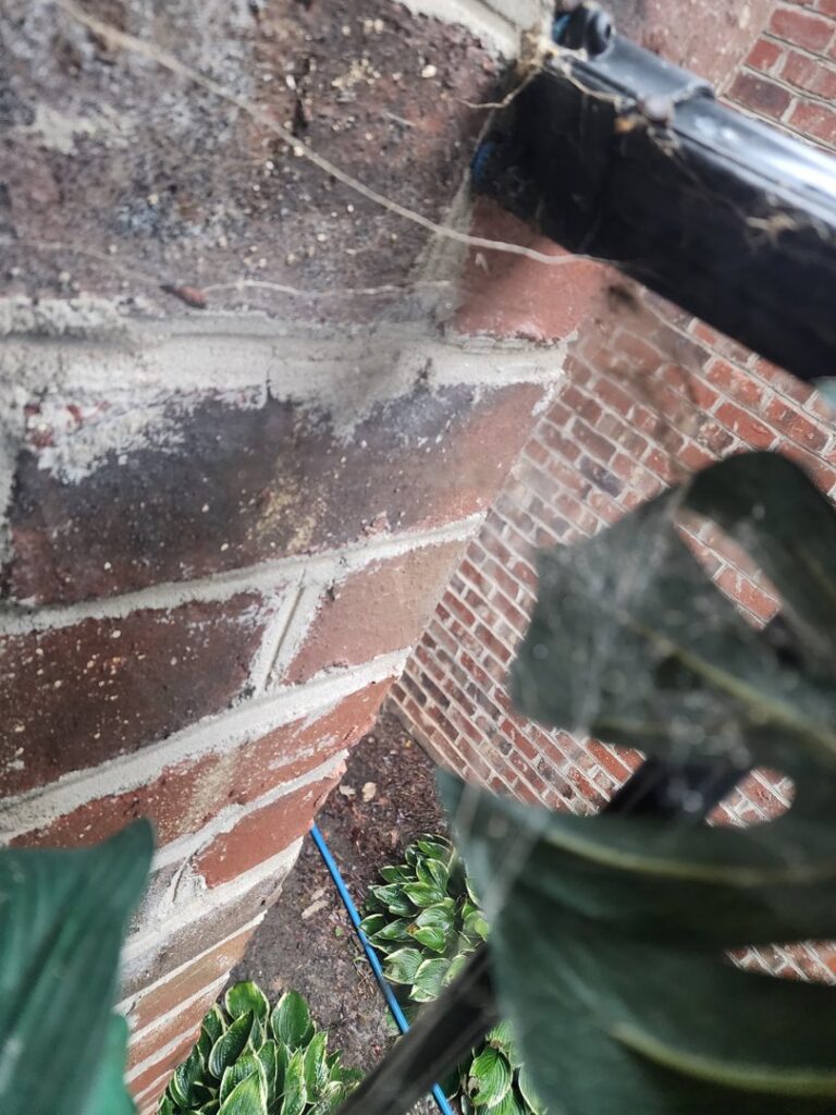 A dirty black porch swing covered in spiderwebs, showing a need for pest control from Moxie Pest Control Charlotte in Charlotte, NC.
