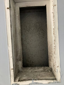 A dirty rectangular air vent opening, showing significant dust and debris accumulation, cleaned by Star Quality Air Duct Cleaning in Silver Spring, MD.