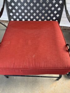 A dirty red chair cushion before upholstery cleaning service by Magic Clean Plus in Ann Arbor, MI.