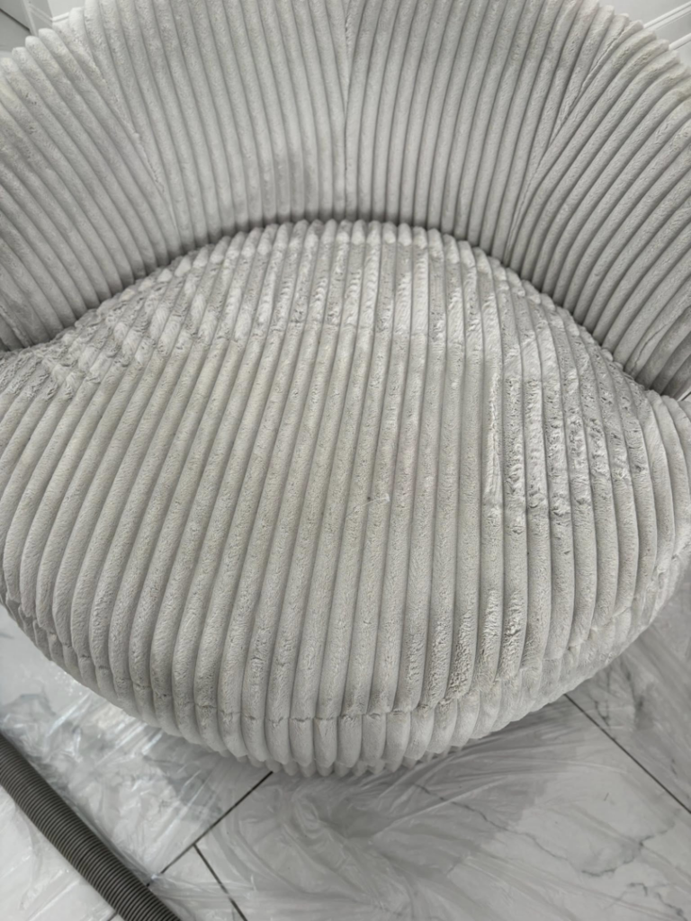 A close-up of a dirty ribbed upholstered chair being cleaned by White Diamond Carpet Cleaners in Baton Rouge, LA.