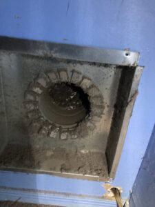 A dirty round air duct opening with visible mold or heavy dust accumulation, requiring cleaning by Star Quality Air Duct Cleaning in Silver Spring, MD.