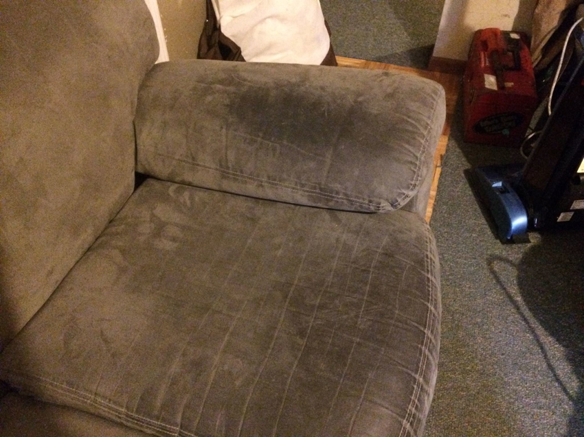 A dirty sofa and carpet before cleaning, showing the need for services from MC Carpet & Upholstery in St. Louis, MO.