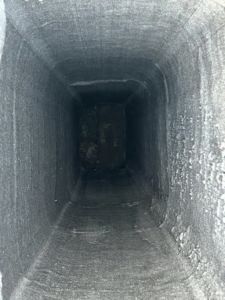 An interior view of a dirty, soot-covered chimney flue during an inspection by Soot Busters in Birmingham, AL.