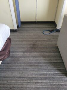A dirty, striped carpet in a commercial or residential setting, awaiting cleaning by Leo's Carpet Cleaning in Omaha, NE