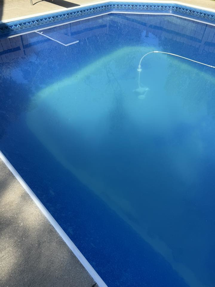 A dirty swimming pool with a vacuum hose, showing a pool cleaning job in progress by KS Pool Co. LLC in Auburn, AL.