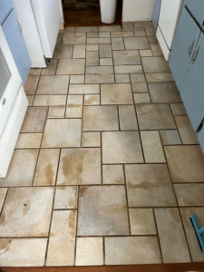 A dirty tile floor before professional cleaning by The Barreto Brothers Carpet Cleaning in Sacramento, CA