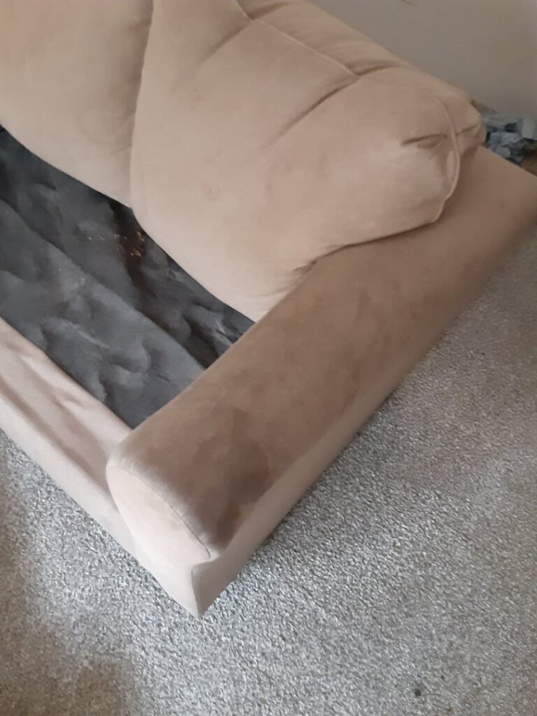 A dirty upholstered sofa armrest showing stains before cleaning by Tex A Clean Carpet Care in League City, TX.