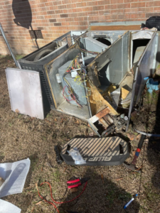 A disassembled outdoor HVAC unit undergoing repair by All American Heating Air & More LLC in Wilson, NC.
