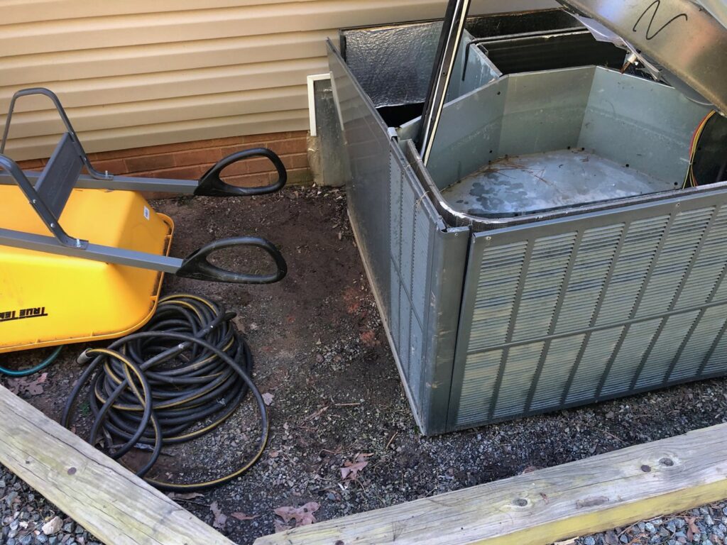 A disassembled outdoor AC unit showing internal components, indicating repair or replacement by G&G Heating and Air in Portage, MI.