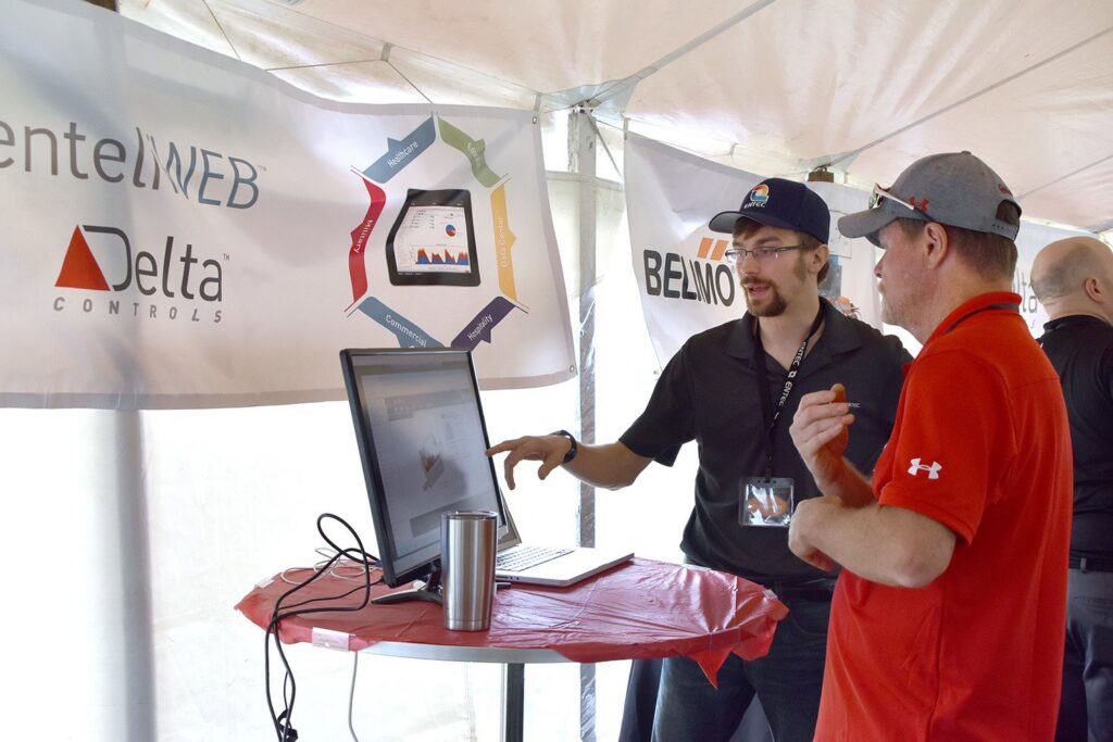 Two professionals discussing HVAC building automation and control systems at an event for ENTEC Services, Inc. in Bartonville, IL
