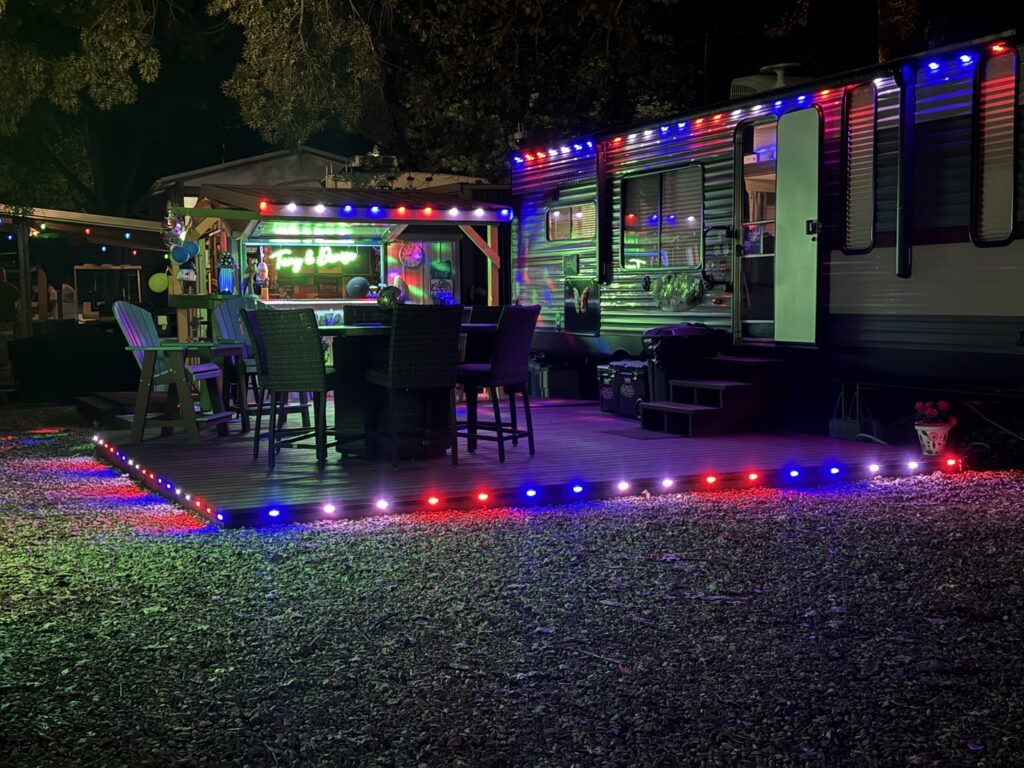 Red and blue decorative lighting illuminating a dock and boathouse by Get Lit KC & LOZ in Kansas City, KS.