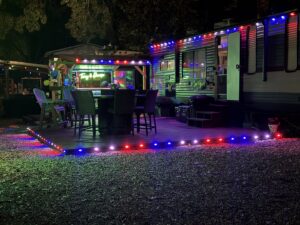 Red and blue decorative lighting illuminating a dock and boathouse by Get Lit KC & LOZ in Kansas City, KS.