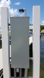 An outdoor electrical panel and light fixture installed on a dock or pier by Positricity in Clearwater, FL.