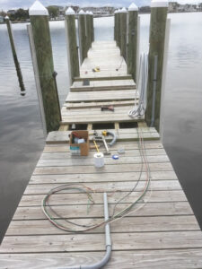 Electrical wiring and conduit laid out on a wooden dock for installation by RTF Electric LLC in Toms River, NJ.