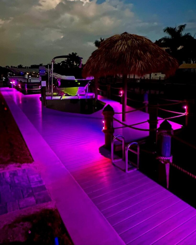 A dock with vibrant purple LED lighting installed by Sound Electric LLC in Saint James City, FL.