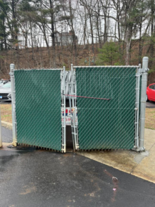 A newly installed double chain-link gate with green privacy slats by Oxford Fence Company in Oxford, CT.