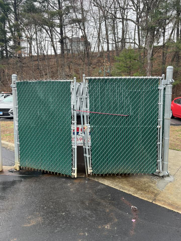 A newly installed double chain-link gate with green privacy slats by Oxford Fence Company in Oxford, CT.