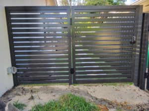 A newly installed dark gray double horizontal slat gate by Southeastern Fence Corp. in Pembroke Pines, FL.