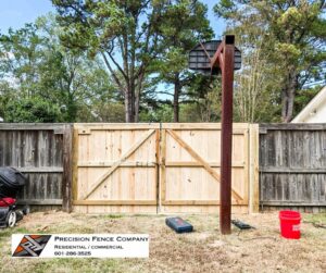 Large double wood gates installed in a residential backyard by Precision Fence in Meridian, MS.