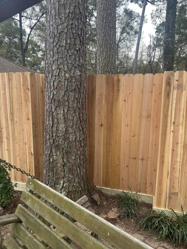 A newly installed double wood gate with decorative hinges by Wood Fence Houston in Houston, TX.