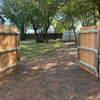 Double wooden fence gates opening into a residential backyard installed by Frontline Fence Company in Fulton, NY