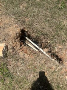 Drainage pipes being installed in a hole in the ground by L&L Lawn Care Service in Dothan, AL.