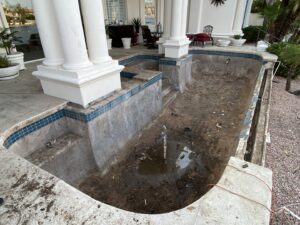 A drained and very dirty swimming pool, showing the need for a thorough cleaning service by AZ Pool Love in Mesa, AZ