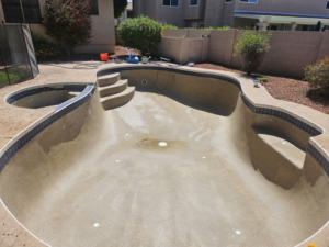 A drained and dirty residential pool before cleaning service by Vanguard Pool Care in Phoenix, AZ